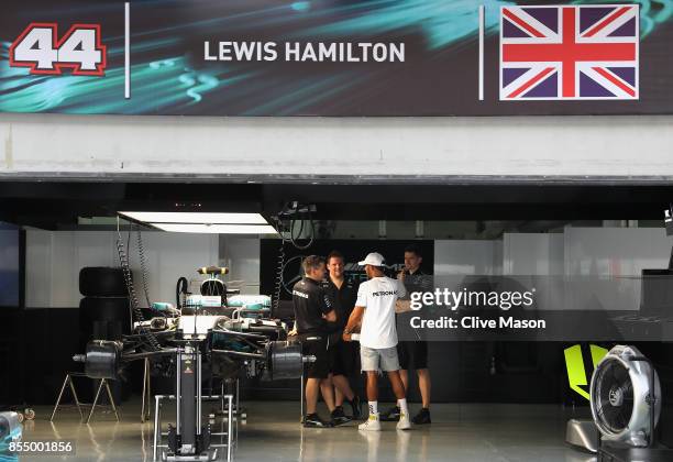 Lewis Hamilton of Great Britain and Mercedes GP walks with his team in the garage during previews for the Malaysia Formula One Grand Prix at Sepang...