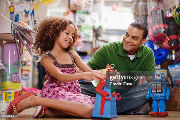 father and daughter in toy store - loja de brinquedos imagens e fotografias de stock