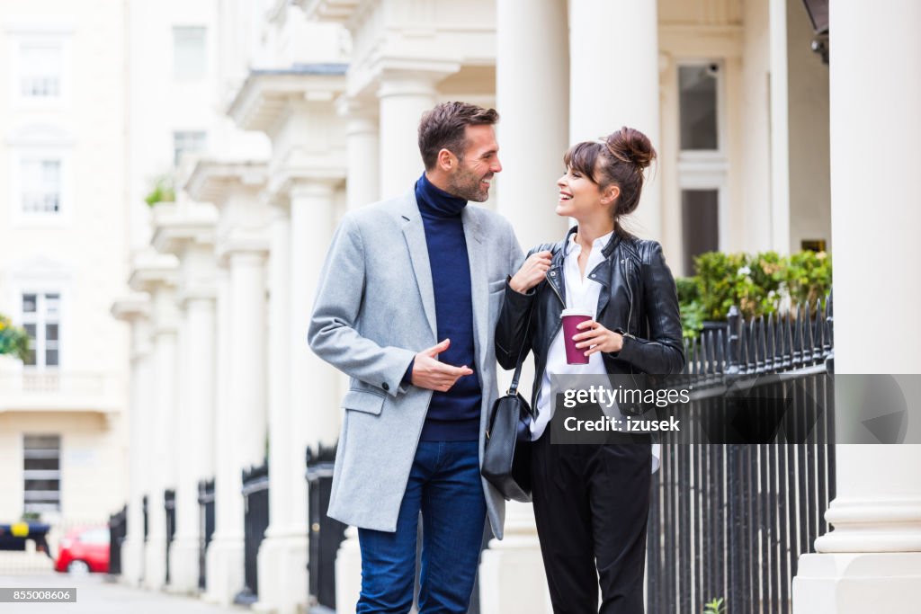 Elegante paar wandelen in de straat van de stad, gesprek