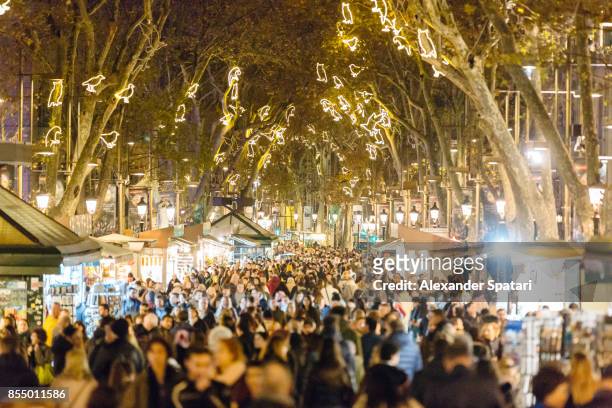 people walking at la rambla street during christmas and new year holidays in barcelona, catalonia, spain - barcelona españa fotografías e imágenes de stock