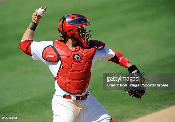 Yadier Molina of the St. Louis Cardinals defends his position against the Washington Nationals during a spring training game at Roger Dean Stadium on...