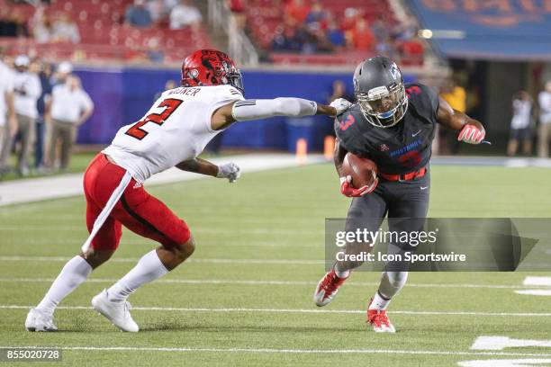 Mustangs wide receiver James Porch turns up field and tries to avoid the tackle of Arkansas State Red Wolves cornerback Nehemia Wagner during the...