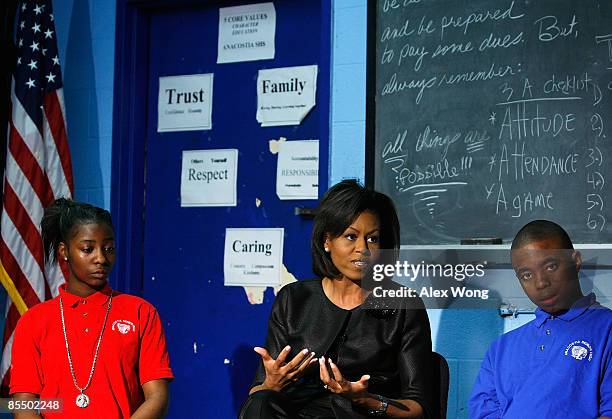 First lady Michelle Obama speaks to students as Tiara Nicole Chance and Marvin Grant Tucker listen during her visit to Anacostia High School March...