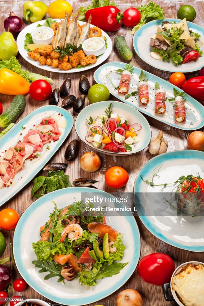 Ensemble de divers plats de la cuisine méditerranéenne, les légumes et les herbes sur une table en bois
