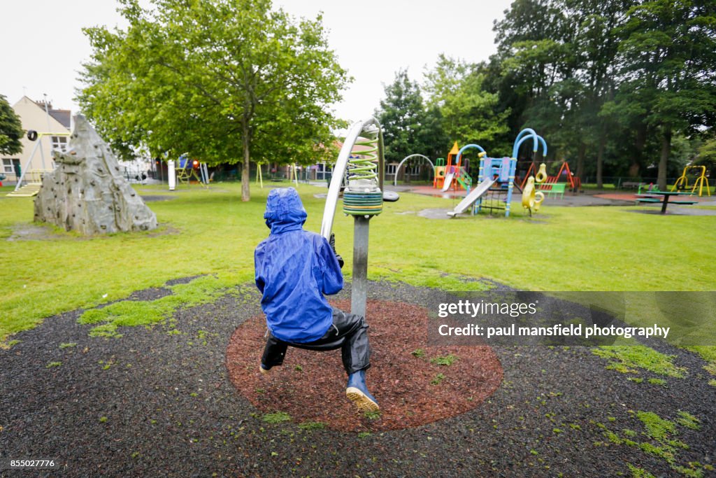 Boy at playground on a rainy day