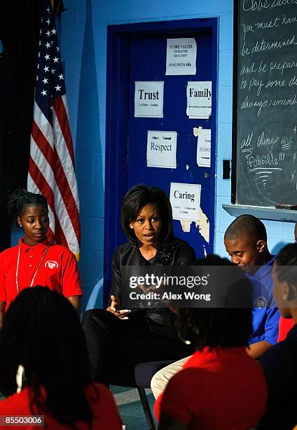 First lady Michelle Obama speaks to students as Tiara Nicole Chance and Marvin Grant Tucker listen during her visit to Anacostia High School March...