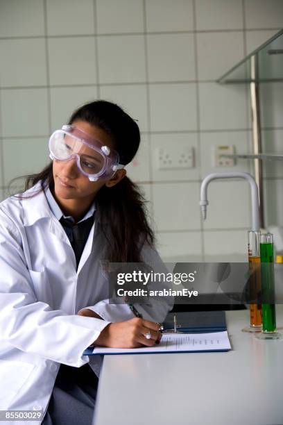 a student writing a report for an experiment in a chemical laboratory. - laboratory report stock pictures, royalty-free photos & images
