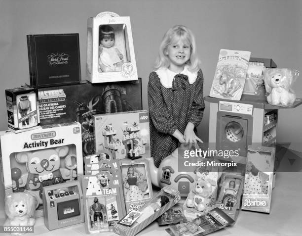 Young girl with a selection of children's toys for Christmas, 6th December 1984.