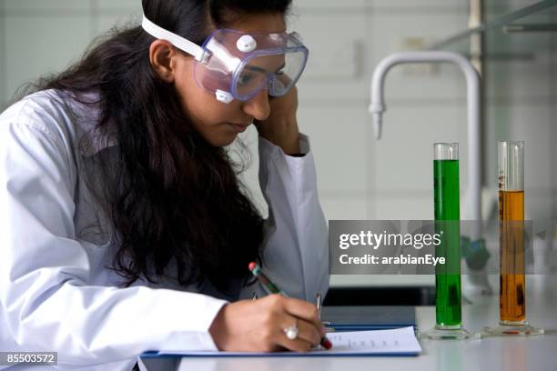 a student writing a report for an experiment in a chemical laboratory. - laboratory report stock pictures, royalty-free photos & images