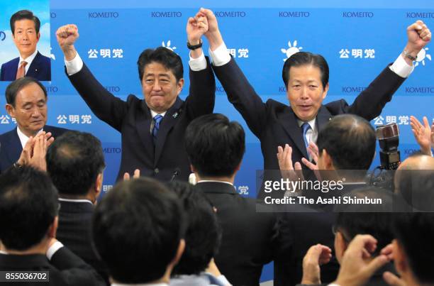 Prie Minister and ruling Liberal Democratic Party President Shinzo Abe and the LDP's junior coalition Komeito leader Natsuo Yamaguchi raise their...
