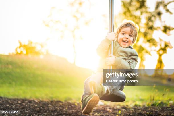 happy laughing little boy on zipline in bright sunshine - toddler laughing stock pictures, royalty-free photos & images