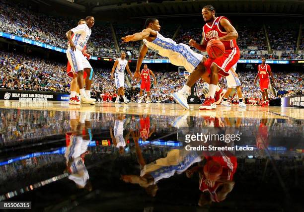 Amir Johnson of the Radford Highlanders drives into Larry Drew II of the North Carolina Tar Heels during the first round of the NCAA Division I Men's...
