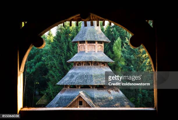romanian wooden monastery surrounded by lush green forest - maramureș stock pictures, royalty-free photos & images