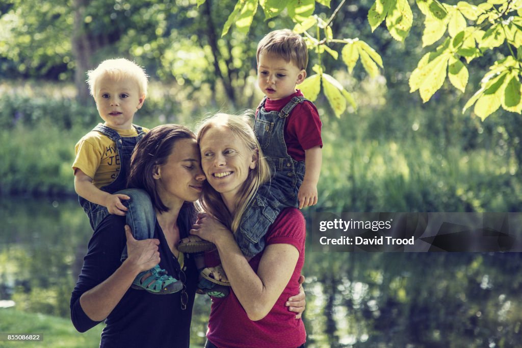 Lesbian couple embracing with their children