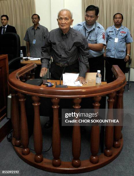 Security officer assists former Khmer Rouge leader Nuon Chea at the tribunal in the Court of Cambodia in Phnom Penh on February 4, 2008. Nuon Chea...