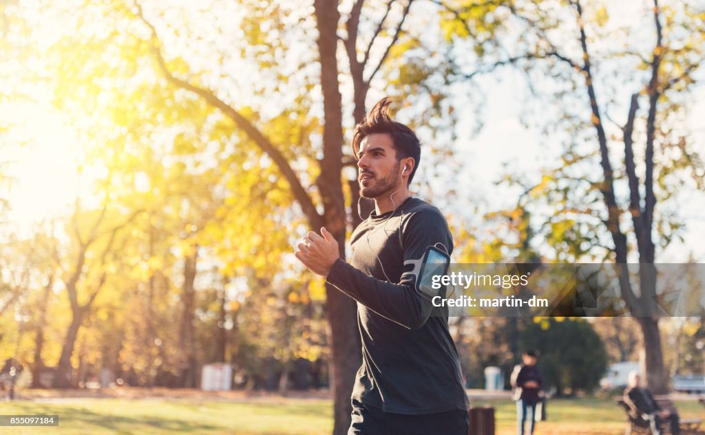 Sportsman jogging in the autumn park