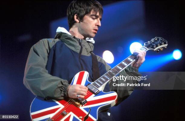 Noel Gallagher performing live onstage, playing Epiphone Sheraton Union Jack guitar at Maine Road, April 1996.