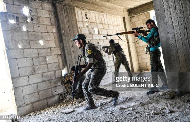 Members of the Syrian Democratic Forces fire their arms during a battle against Islamic State group jihadists to retake the central hospital of Raqa...