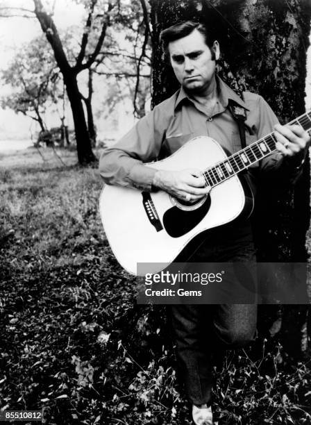 Circa 1970: Photo of Country musician George JONES posed playing an acoustic guitar circa 1970.
