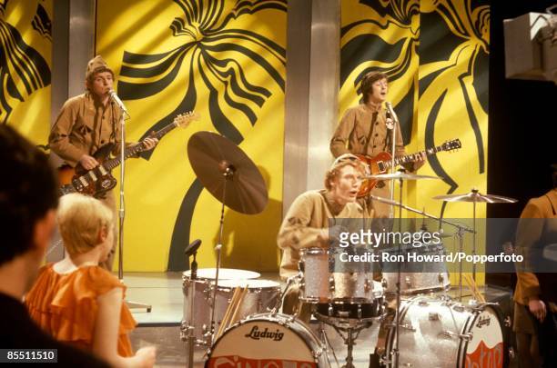 British rock group Cream perform wearing prison uniforms on the set of a pop music television show in London in December 1966. Members of the band...