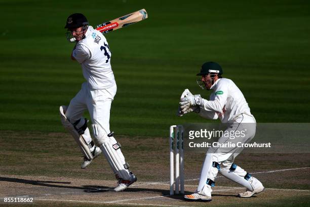 Luke Wells of Sussex hits out while Nottingham keeper Chris Read looks on during day four of the Specsavers County Championship Division Two match...