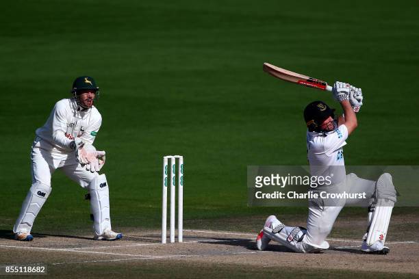 Harry Finch of Sussex hits out while Nottingham keeper Chris Read looks on during day four of the Specsavers County Championship Division Two match...