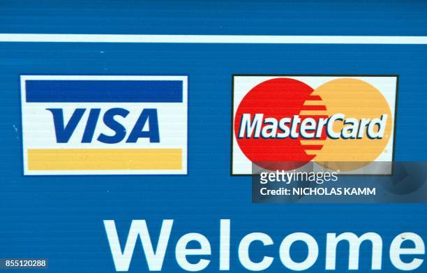 Visa and MasterCard credit card logos are seen on a sign in Washington on March 30, 2012. Credit card giants Visa and MasterCard were scrambling to...
