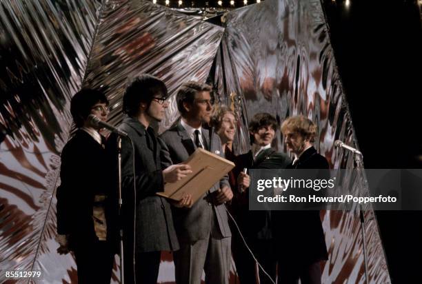 English rock group Manfred Mann stand with presenter Pete Murray on the set of a pop music television show in London circa 1966. Members of the band...