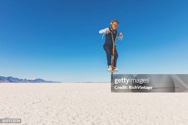 business boy jumping on pogo stick - pogo imagens e fotografias de stock