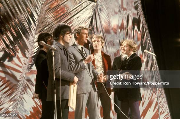 English rock group Manfred Mann stand with presenter Pete Murray on the set of a pop music television show in London circa 1966. Members of the band...