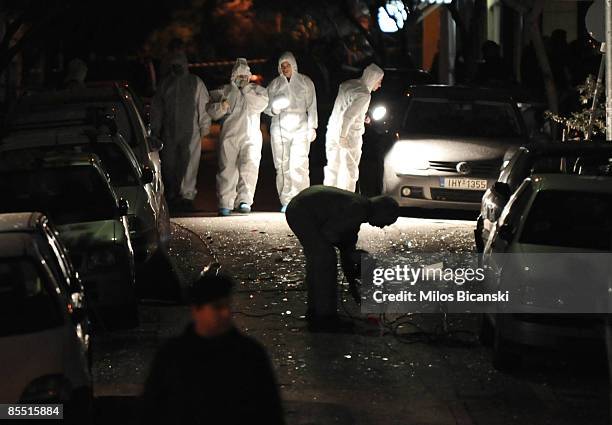 Police officers search for evidence following a bomb explosion that damaged a building of an agency managing state property, on March 19, 2009 in...