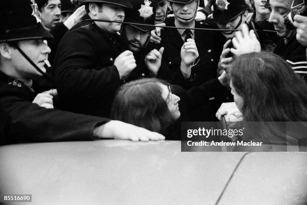 Photo of John LENNON and BEATLES; John Lennon, surrounded by the police, as they try to get in to a car to leave Marylebone Magistrates Court after...