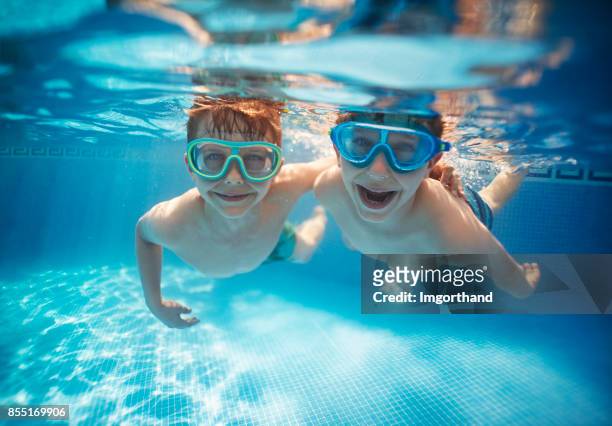 fratellini che vincolano sott'acqua insieme - boy swim foto e immagini stock