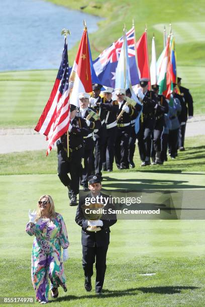 Cheryl Lee and son Mark Lee Jr. Deliver the Presidents Cup to the first tee prior to Thursday foursome matches of the Presidents Cup at Liberty...