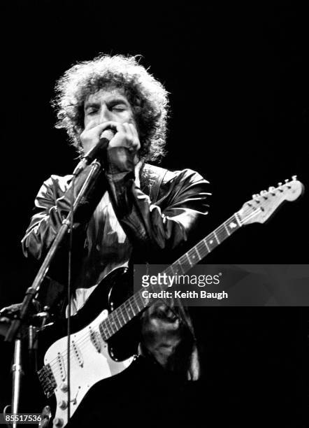 Photo of Bob DYLAN, Bob Dylan performing on stage, playing harmonica