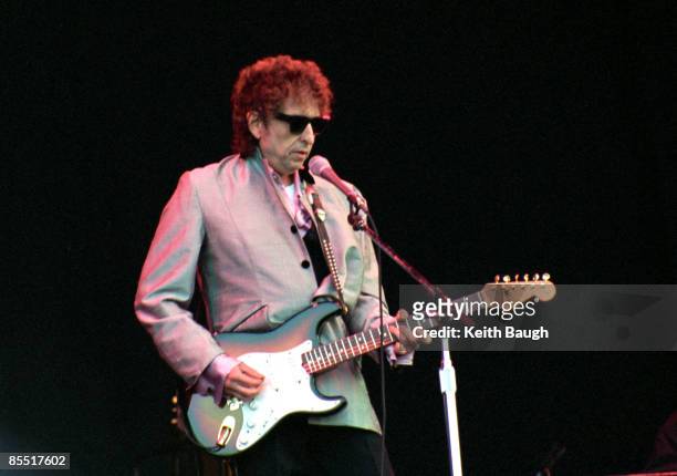 Photo of Bob DYLAN; Bob Dylan performing on stage, sunglasses