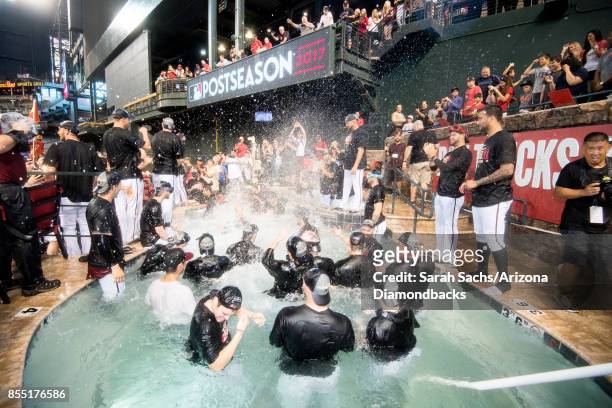 The Arizona Diamondbacks celebrate in the pool after defeating the Miami Marlins and clinching a postseason berth following the MLB game at Chase...