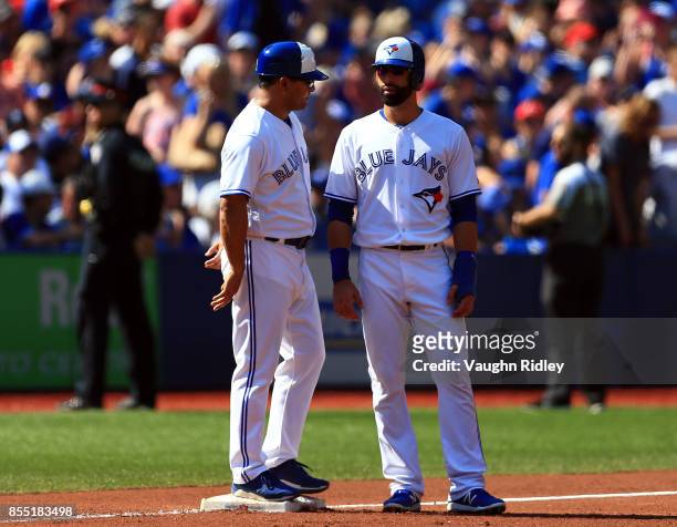 Jose Bautista of the Toronto Blue Jays talks to third base coach Luis Rivera during a MLB game against the New York Yankees at Rogers Centre on...
