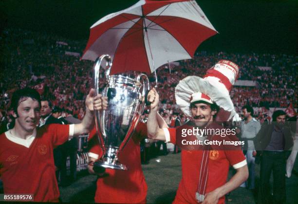 Liverpool players Jimmy Case and Terry McDermott celebrate with the trophy after their victory over Borussia Moenchengladbach in the European Cup...