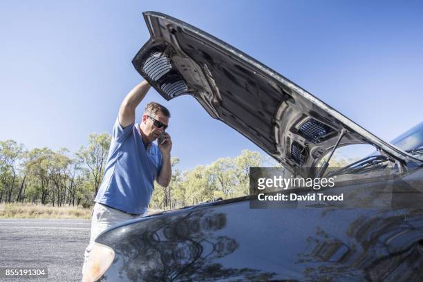 man with broken down car by roadside. - david trood stock pictures, royalty-free photos & images