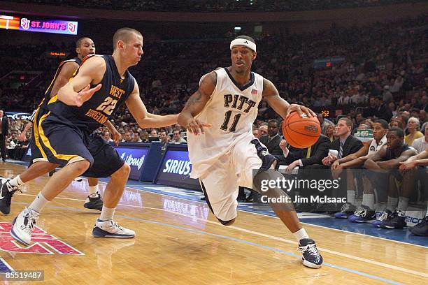 Gilbert Brown of the Pittsburgh Panthers drives the ball against Alex Ruoff of the West Virginia Mountaineers during the second round of the Big East...