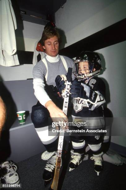 Wayne Gretzky of the Los Angeles Kings helps his son Ty Gretzky with putting on gear on November 7, 1993 at the Great Western Forum in Inglewood,...