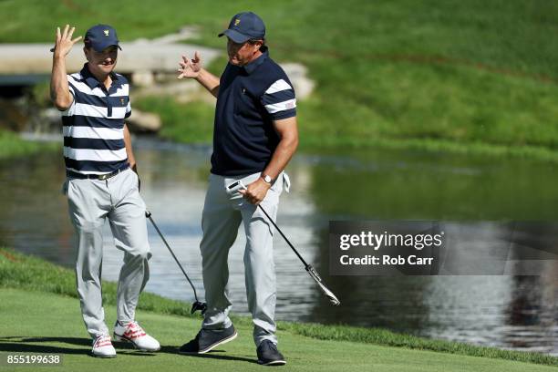 Kevin Kisner and Phil Mickelson of the U.S. Team celebrate on the first green after going one up against Jason Day and Marc Leishman of Australia and...