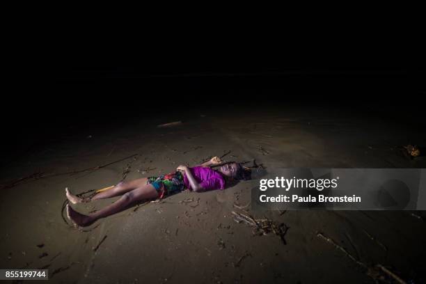 The body of a Rohingya woman lays on a beach washed up after a boat sunk in rough seas off the coast of Bangladesh carrying over 100 people September...