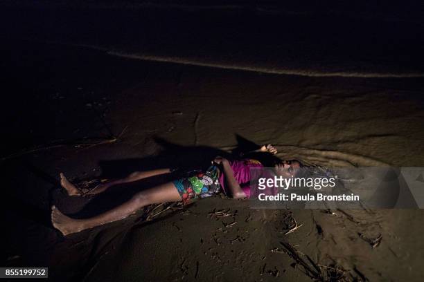 The body of a Rohingya woman lays on a beach washed up after a boat sunk in rough seas off the coast of Bangladesh carrying over 100 people September...