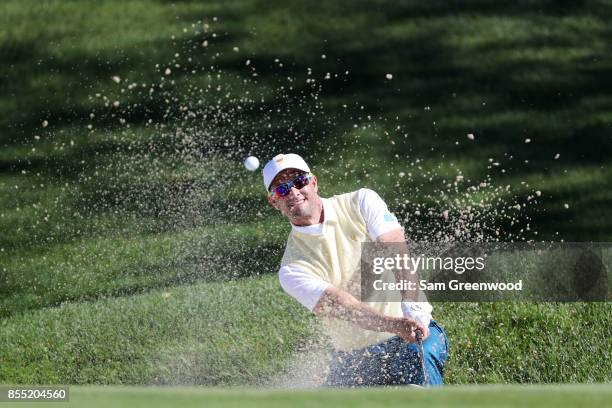 Adam Scott of Australia and the International Team plays a shot from a bunker on the fourth hole during Thursday foursome matches of the Presidents...