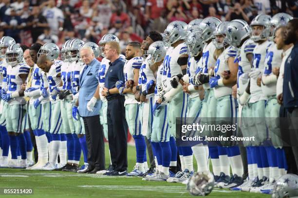 Dallas Cowboys owner Jerry Jones and head coach Jason Garrett link arms with their team during that national anthem prior to the NFL game against the...