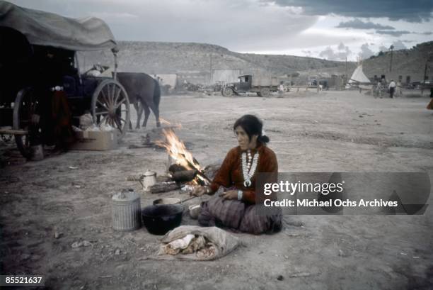 S: A Native American woman cooks by the camp fire during the Inter-Tribal Indian Ceremonial circa late 1940's in Gallup, New Mexico.