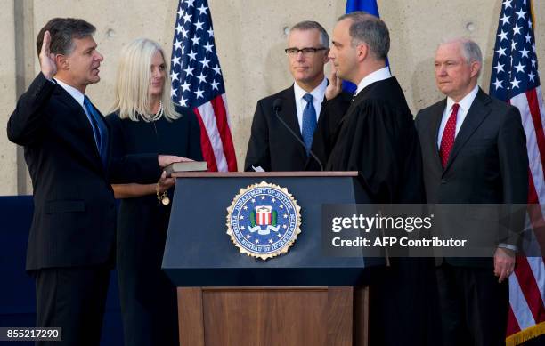 Director Christopher Wray takes a ceremonial oath alongside his wife, Helen , FBI Deputy Director Andrew McCabe , Judge Joseph Bianco and Attorney...