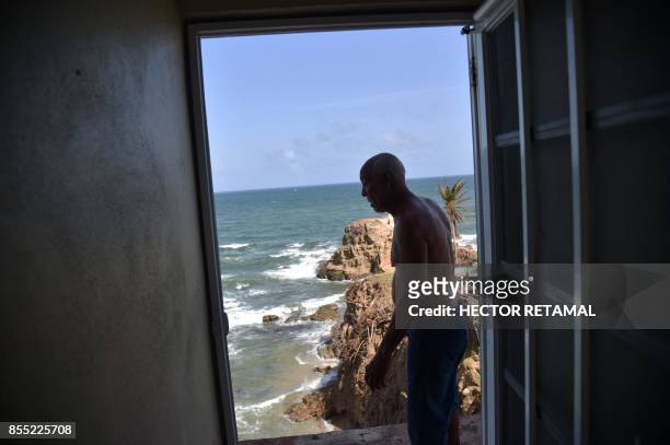 Pablo Pagan walks inside of his home destroyed by Hurricane Maria, in Yabucoa, in the eastern part of Puerto Rico, on September 28 where he and his...